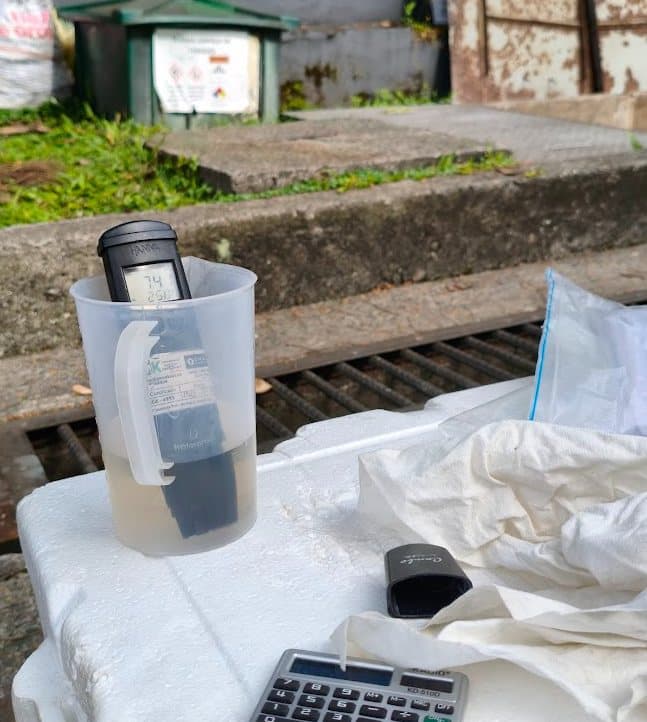 Medidor de pH dentro de una jarra con agua residual durante un muestreo en campo